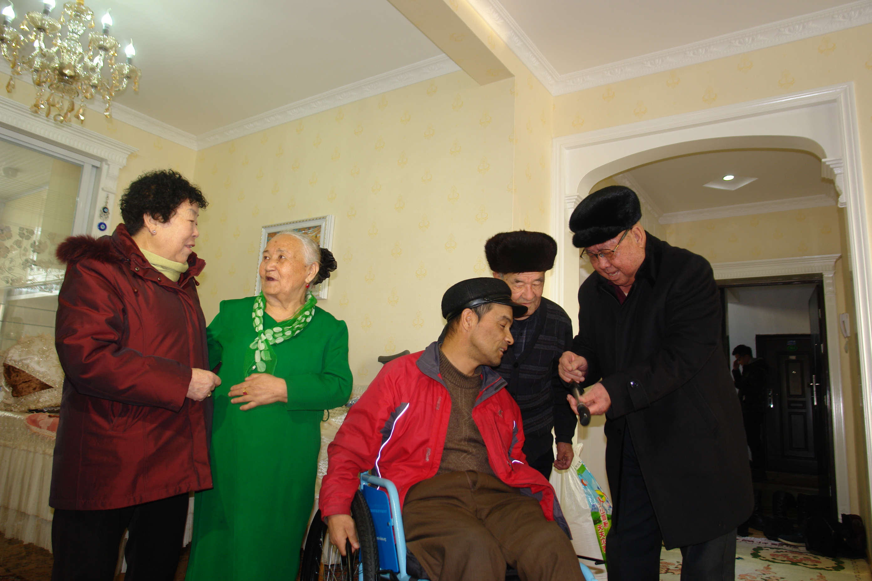 04李金昌向阿吉尼莎老人的儿子示范给轮椅充气.JPG